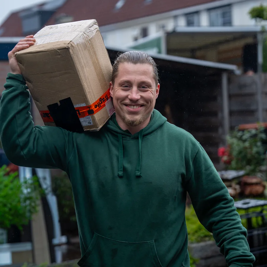 Verhuizer van VerhuisMeesters met een verhuisdoos op zijn schouder